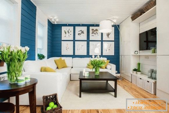 Fehér kanapé a belső térben, kék tapéta és fapadló