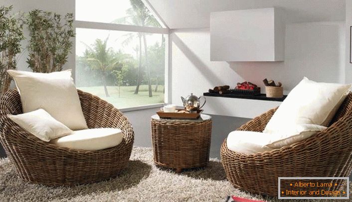 Fehér, puha párnákkal ellátott fonott fotelek, melyek magas bolyhos szőnyeggel rendelkeznek, az eco-stílusú vendégszobának a legjobb dekorációja.