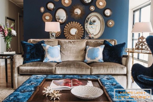 Kék fal és kárpitozott bútorok a nappaliban