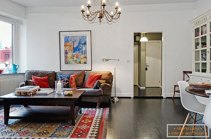 A stílusos vendégszobában egy tipikus városi apartman fényes párnákkal díszített a kanapén és a szőnyegen. 