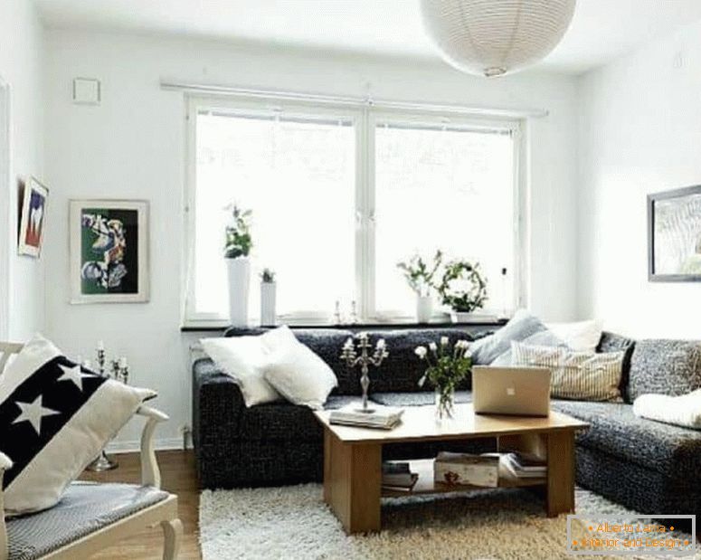 Egy kis nappali fehérben, sötét sarokkanapéval és ablakkal