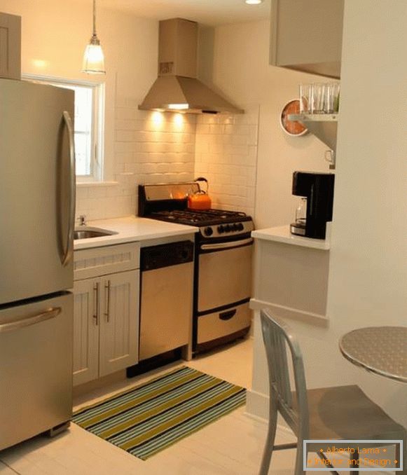 A fényképen egy hűtőszekrénnyel ellátott kis konyha modern kialakítása