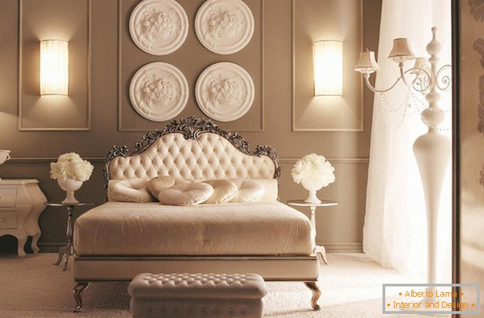 Az ágy fején a fal díszített stukkókészítéssel díszített. Kiváló hálószoba dekoráció az Art Deco stílusban.