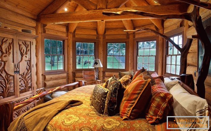 A tó melletti ház egyik hálószobája a vidéki táj stílusa. Fa dekoráció. A masszív bútorokat és díszítő elemeket a legjobb stílus hagyományai választják ki.