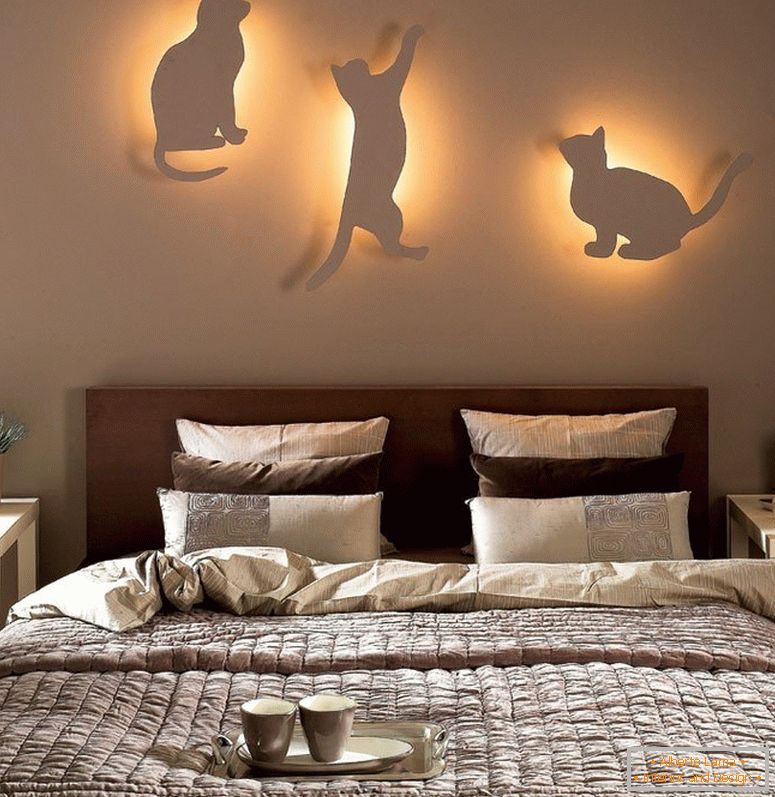Macskák a falon lámpákkal