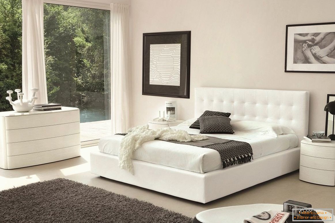Fehér ágy, fiókos szekrény és éjjeliszekrény a hálószobában