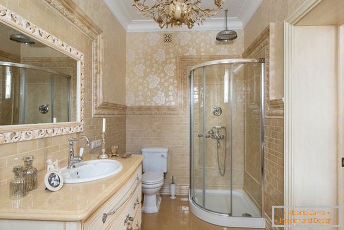 A fürdőszoba neoklasszikus stílusban díszített. A tágas tükör, amelyet egy széles kocka keretez, elkészíti a képet.