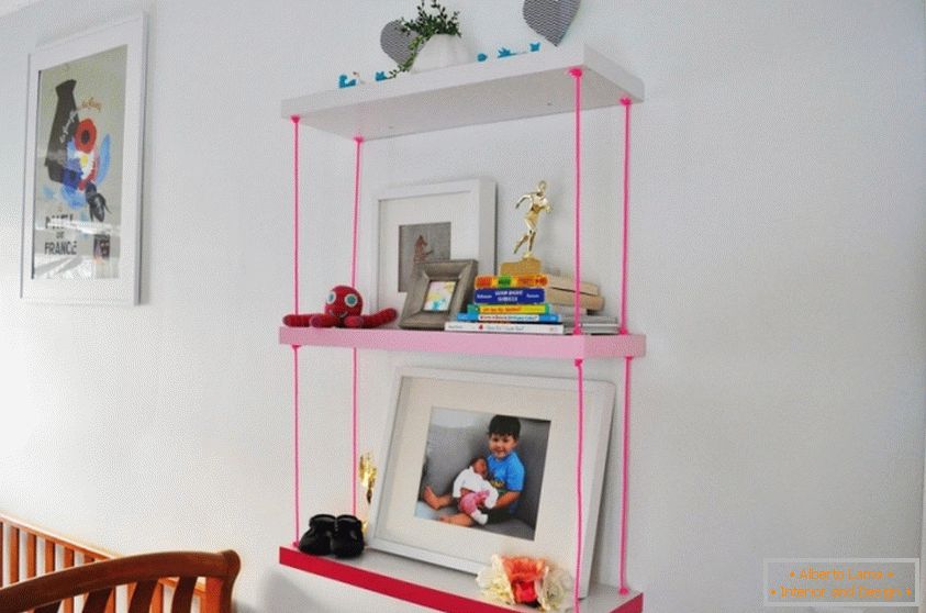 A könyvespolc egy gyermekszoba rózsaszín kötelekkel
