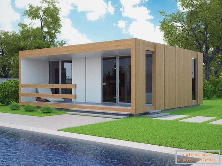 Egy kis moduláris ház medencével az udvaron. Az építés alatt álló ház stílusos kialakítása gyorsan néz ki ökológiai formában egy rövid vágott pázsiton.