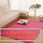 Rózsaszín szőnyeg egy fehér kanapé közelében