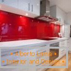 Fehér bútorok és piros kötény a konyhában