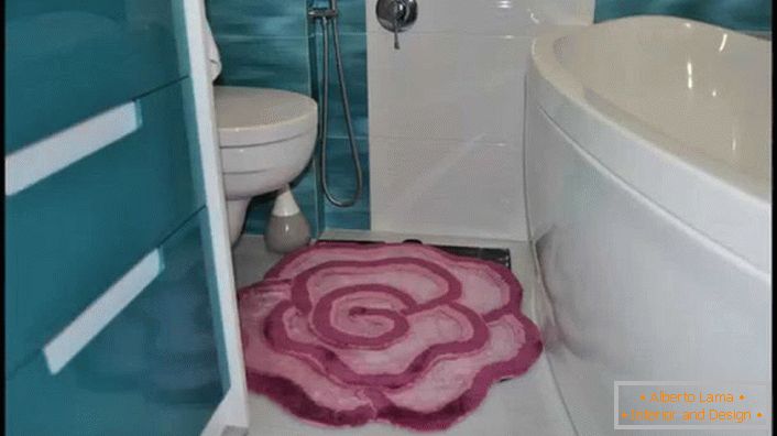 Szőnyeg egy puha rózsaszín rózsa formájában egy kis fürdőszobában. 
