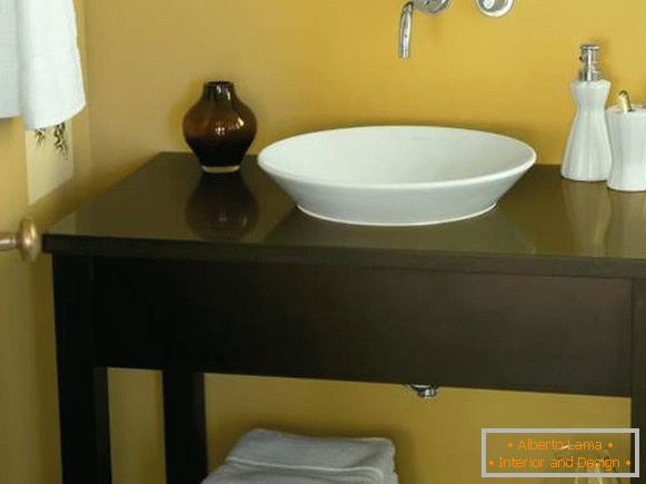 Egy asztal a füves kőr alatt egy mosdó a fürdőszobában a kezét