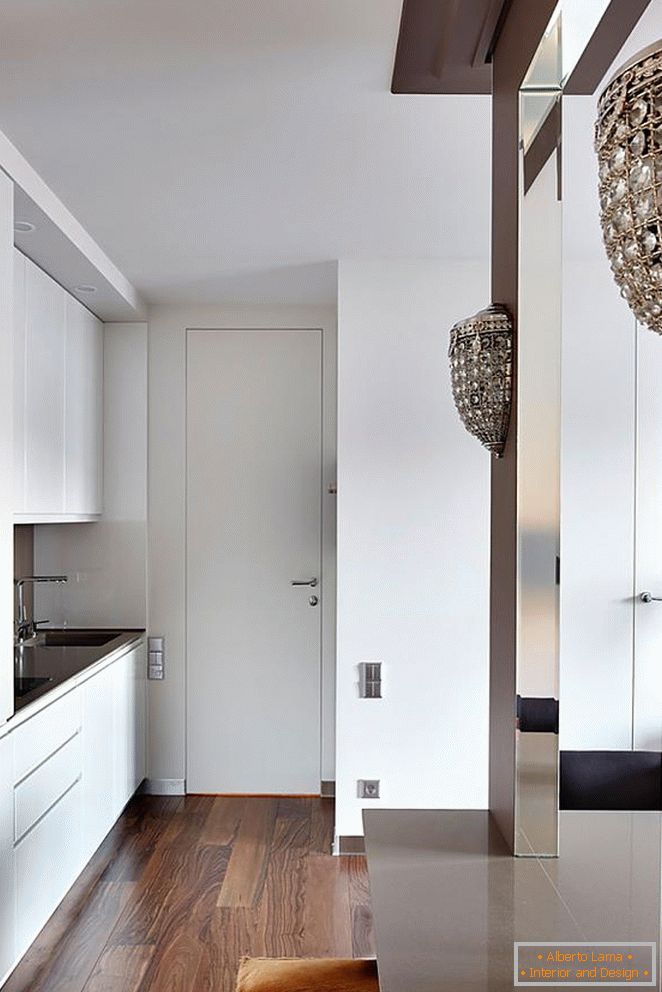 Fehér konyhabútor, fehér bejárati ajtó és gyönyörű fa parketta