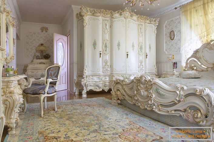 Hófehér hálószoba faragott masszív, fából készült bútorokkal. Az ágy magas fejjel a fejtámla, elegánsan illeszkedik a belső tér a barokk stílusban.