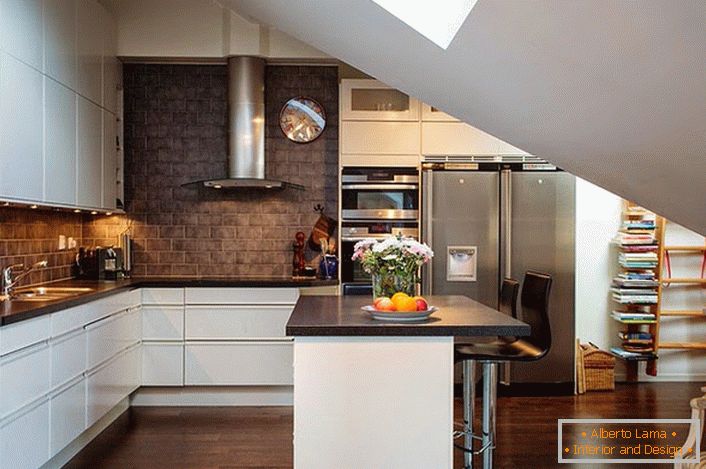 A tetőtérben lévő konyha skandináv stílusban díszített. A fehér konyhai készletek jól néznek ki a sötét téglák falainak hátterében. 