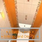 A fehér és narancs csempe kombinációja a WC kialakításában