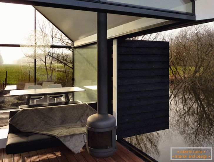 Egy kis üvegház terasza a hollandiai tó mellett