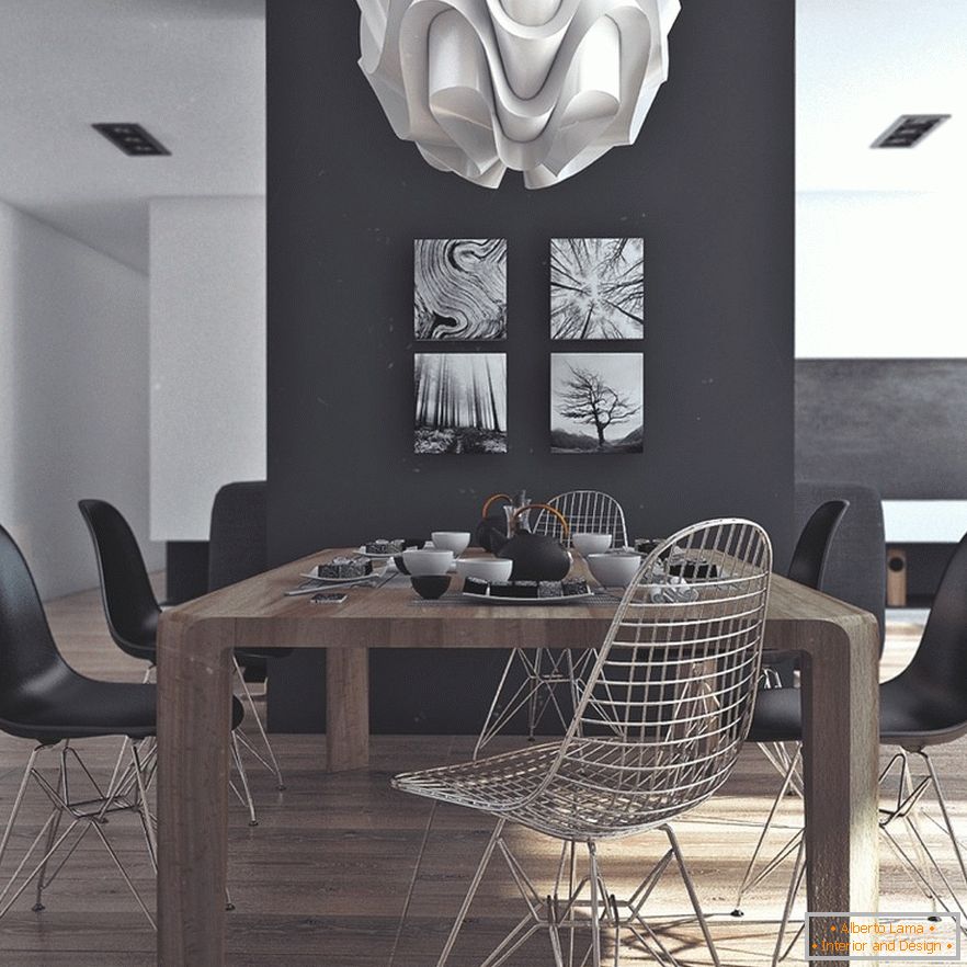 Egy fából készült étkezőasztal, fekete szék és eredeti festmények egy fekete falon