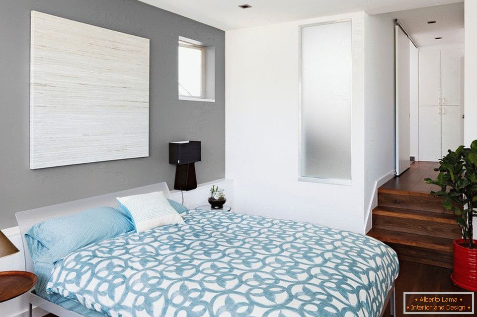 Kék ágynemű és szürke falak a hálószobában