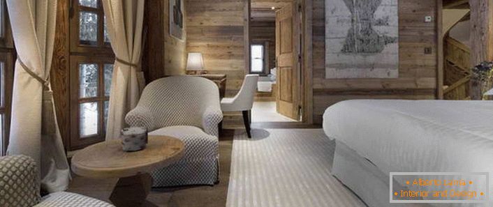 A hálószobában az Alpesi faház stílusa egy ágy, amely hasonlít egy tágas, tollas ágyra.
