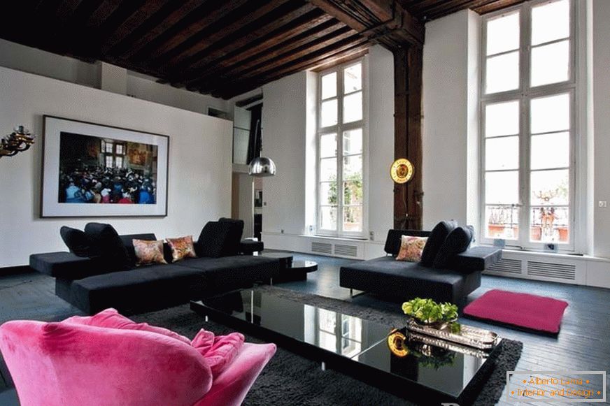 Fekete kanapé és rózsaszín karosszék a szobában