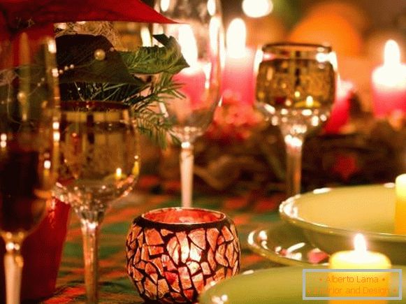Gyönyörű poharak és gyertyák az újévi asztal díszítésében