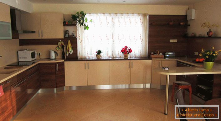 Egy kellemes, nagyméretű, világos bézs színű konyha mahagóni hangulatú, kényelmes bútorokkal.