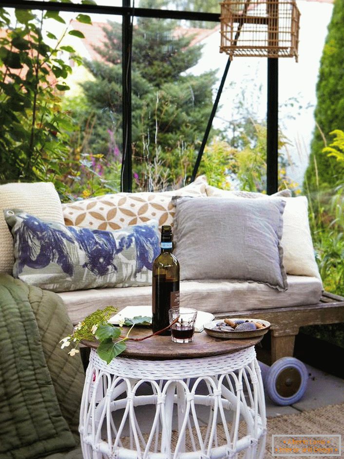 A skandináv stílusú gazebo legjobb dekorációja egy kanapé, sok puha párnával.